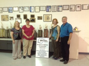 Melody Hamilton, Henrietta Jutson, Melissa Harris, and Jerry Pedley pose for this picture in the front portion of the facility floor at Mertek.