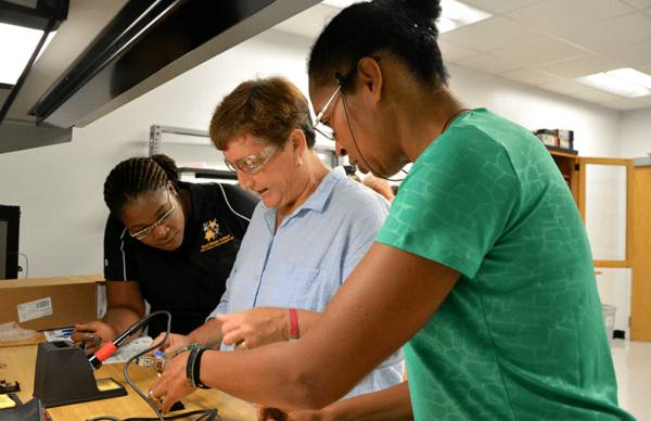 Three teachers working in the lab at the ASSIST Center during their summer industry immersion. Empowering educators is a core function of the Kenan Fellows Program.