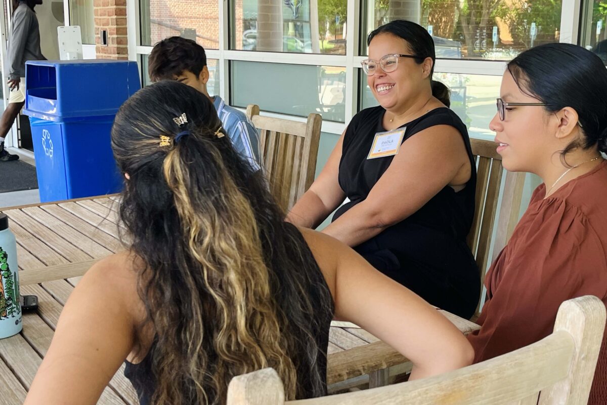 Kenan Fellow Paola De Avila talks with a group of students during a LatinxEd event.