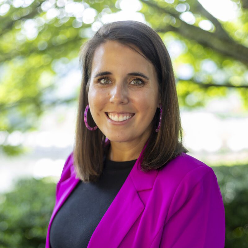 Headshot of Schulte wearing a dark pink blazer over a black top.