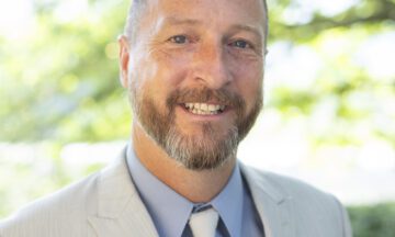 Headshot of Vanzant wearing a light colored blazer, a blue button up shirt and light colored tie.