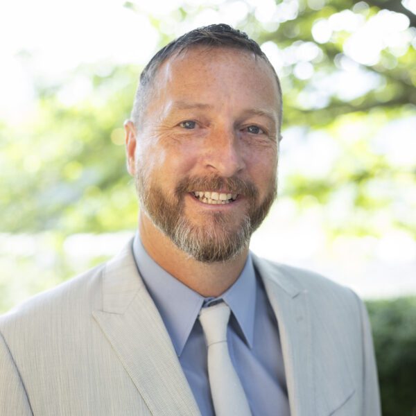 Headshot of Vanzant wearing a light colored blazer, a blue button up shirt and light colored tie.