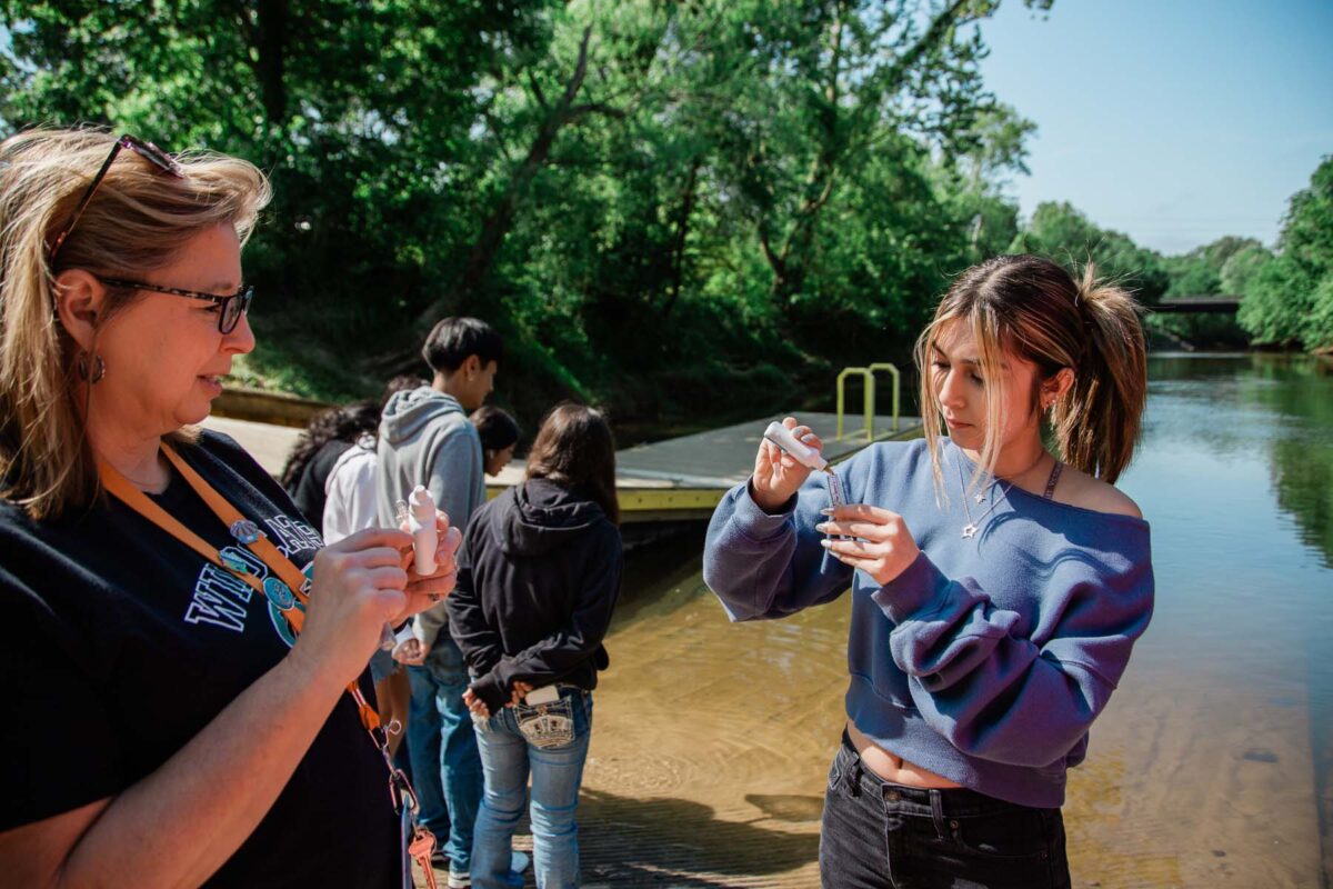 Janice West and a student conduct a water quality test.