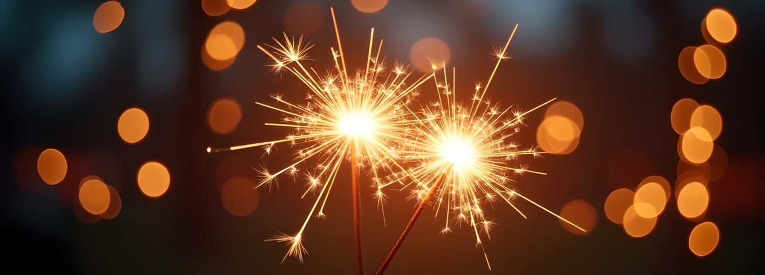 Hands holding burning sparkler with bokeh light background, copy space for text, background for diwali - festival of lights.