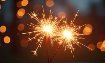 Hands holding burning sparkler with bokeh light background, copy space for text, background for diwali - festival of lights.