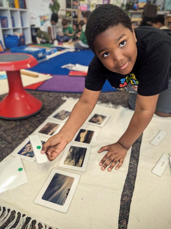 A students shows how he used image cards to learn the different cloud formations.
