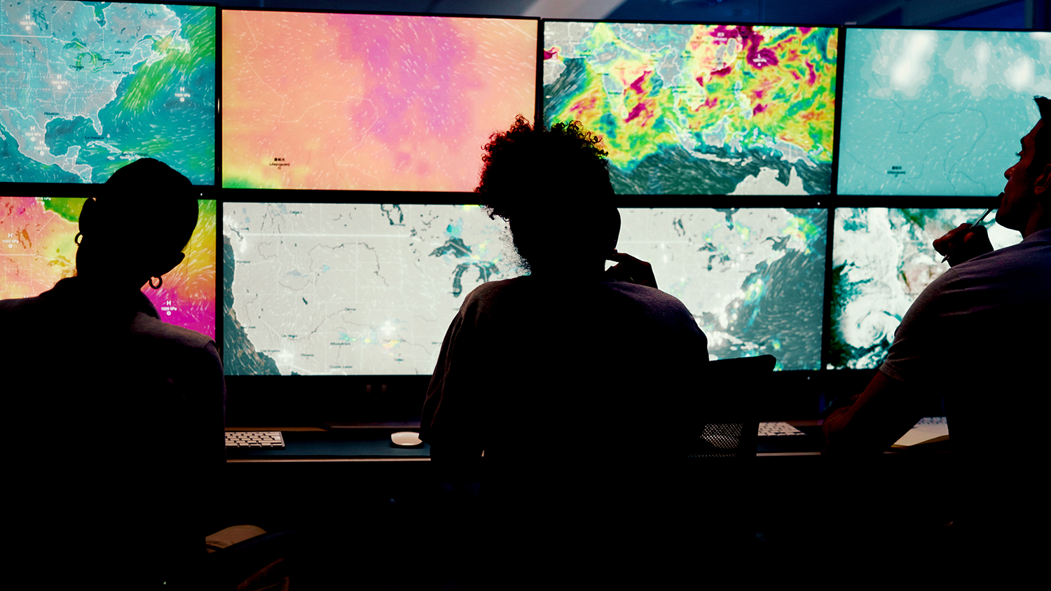 Meteorologists sitting at a weather monitoring station